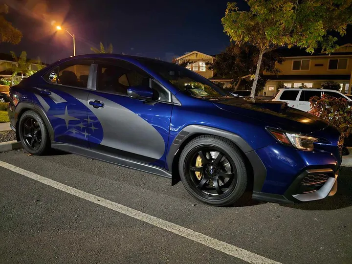 Blue Subaru WRX on black wheels