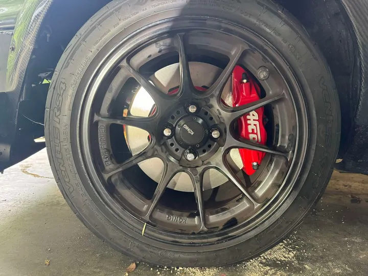 Red caliper behind a black wheel