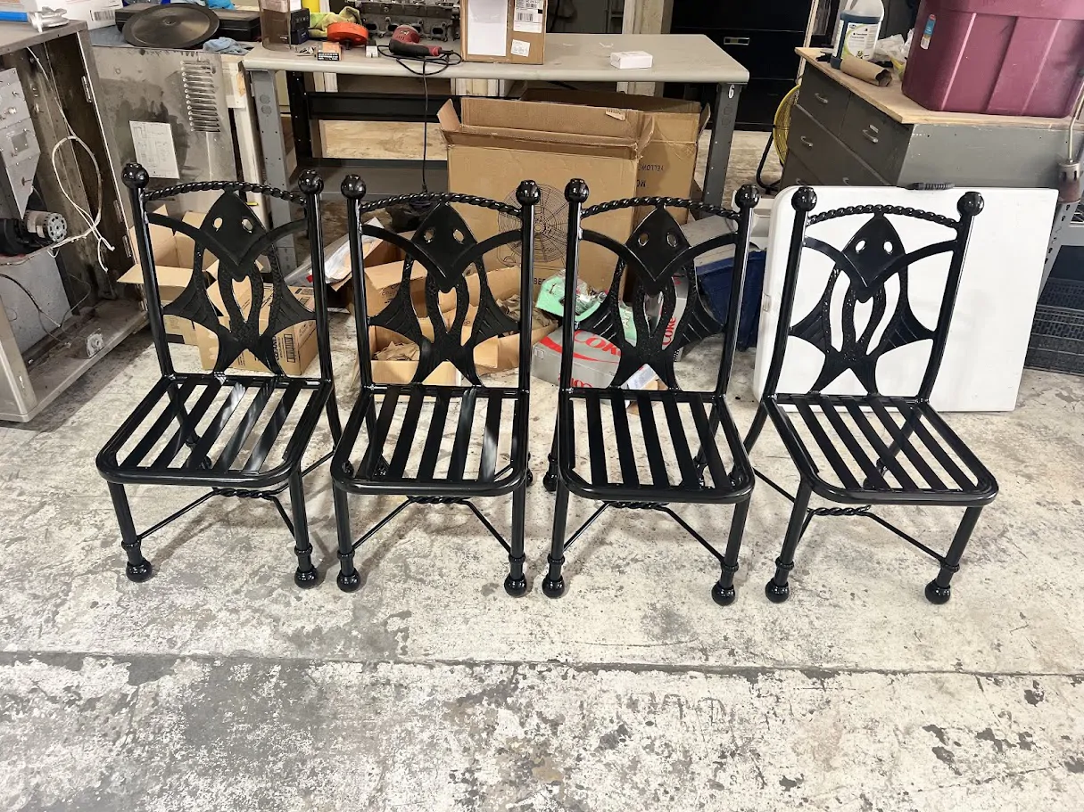 Four black wrought-iron chairs in the shop