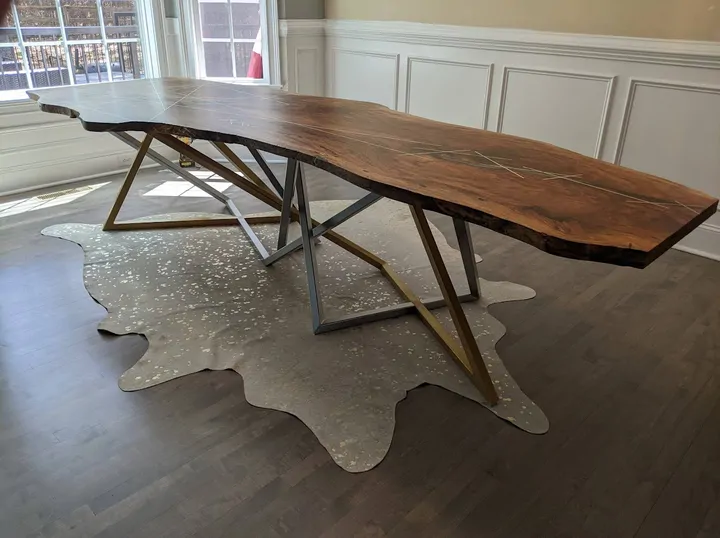 Live-edge wood table on a gold and silver metal base