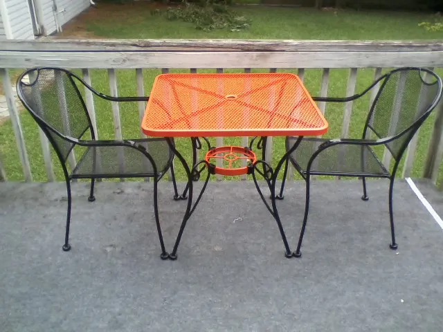 Orange bistro table with black chairs