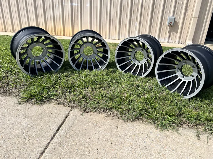 Set of four black and silver wheels lined up outside the shop